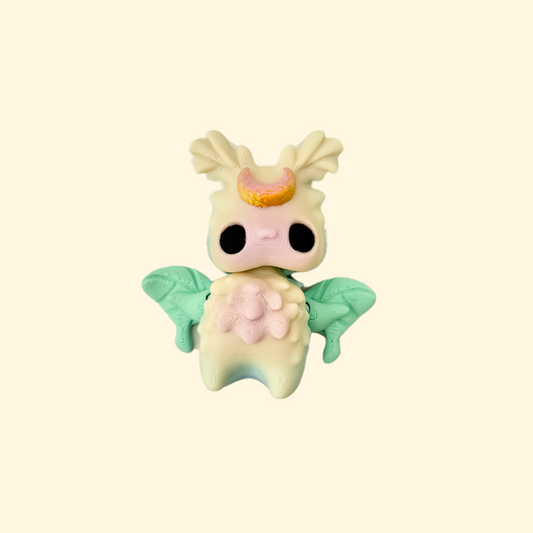 Delicate pastel-toned fidget toy with articulated wings and a bronze moon design