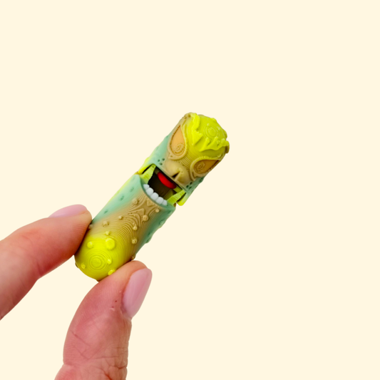 A novelty green pickle fidget with a moving mouth and textured surface for tactile engagement.
