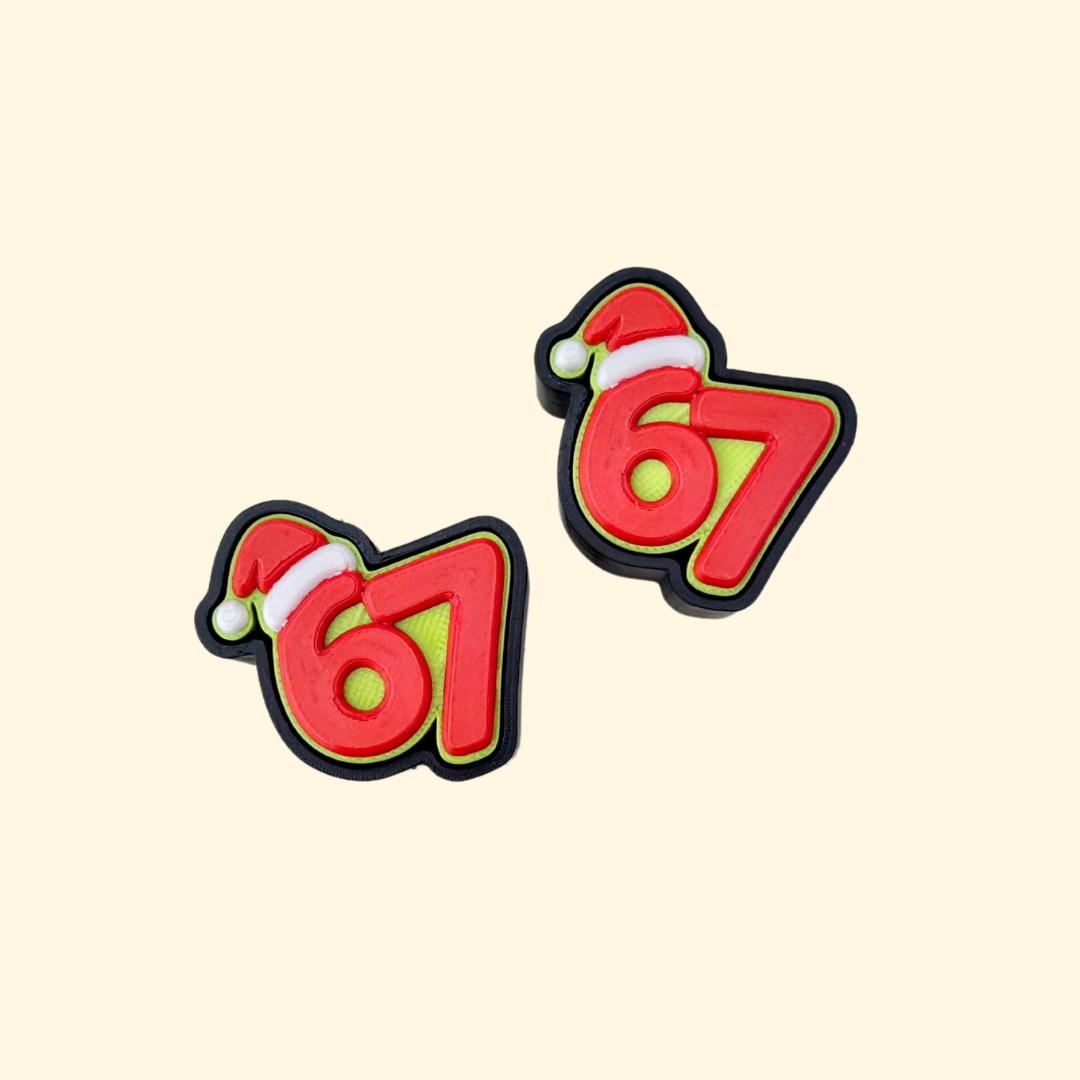 A number-67 Christmas clicker with Santa hat; compact sensory fidget with raised edges and quiet-option available.
