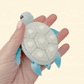 Holiday turtle clicker, durable plastic, rhythmic clicking for regulation and fidget relief.
