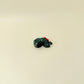 Mini turtle in sparkling evergreen with subtle white berry accents and smooth-to-ridgey tactile surfaces.
