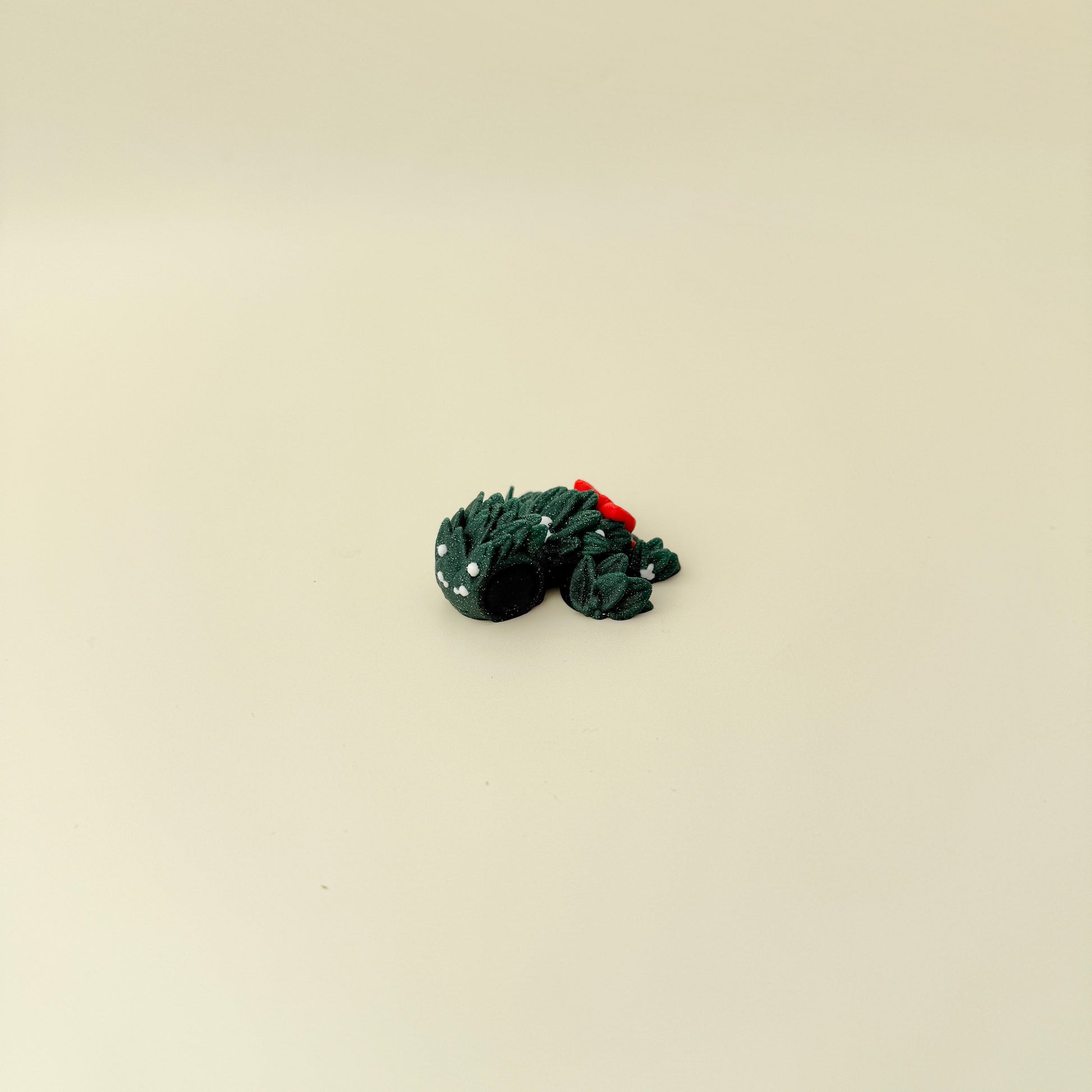 Mini turtle in sparkling evergreen with subtle white berry accents and smooth-to-ridgey tactile surfaces.

