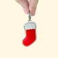 Compact Christmas stocking clicker with glossy white frame, red sparkle inlay, tactile cuff and steel ring; optional quiet upgrade.
