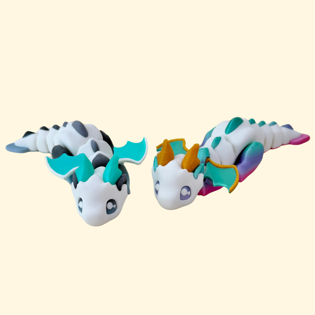 Articulated 16 cm dragon fidget with poseable wings and textured scales, offered in rainbow or greyscale colourways.
