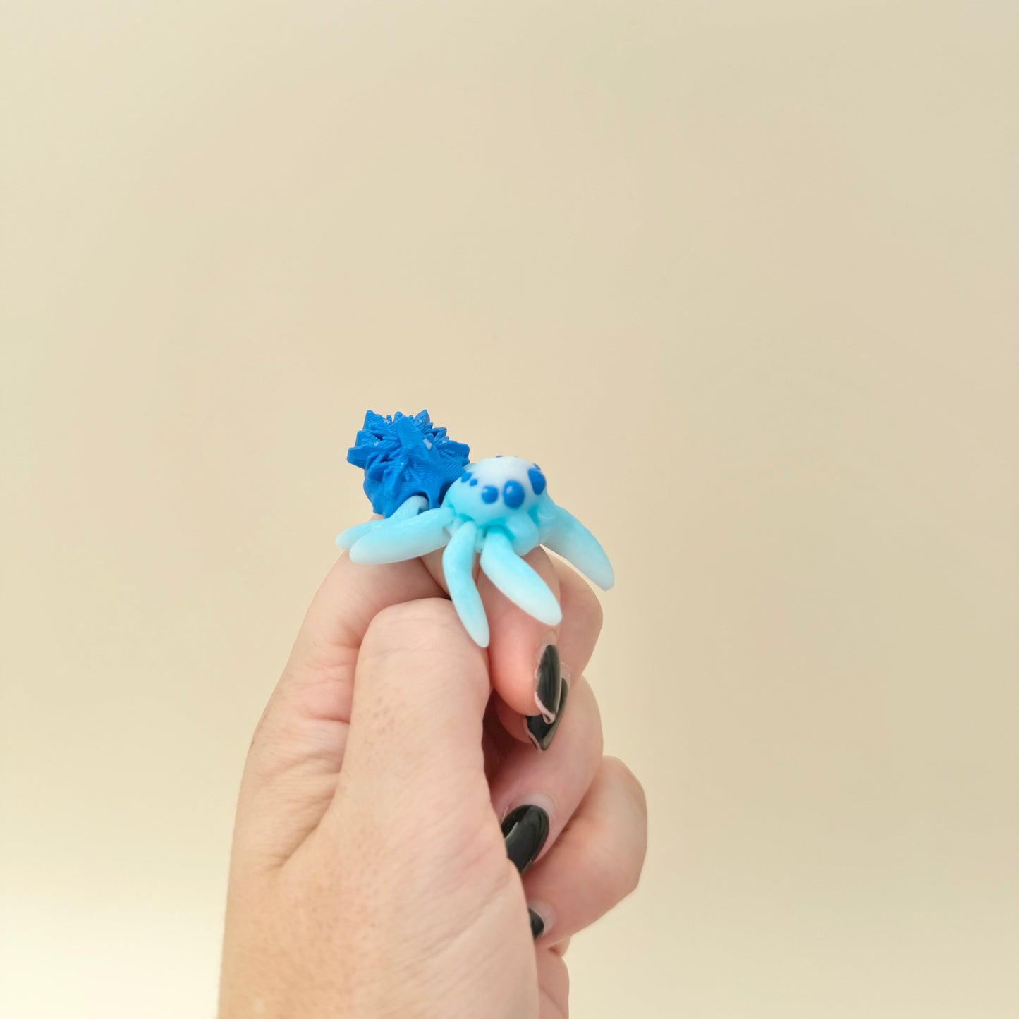 Handheld spider with raised texture and moving legs.
