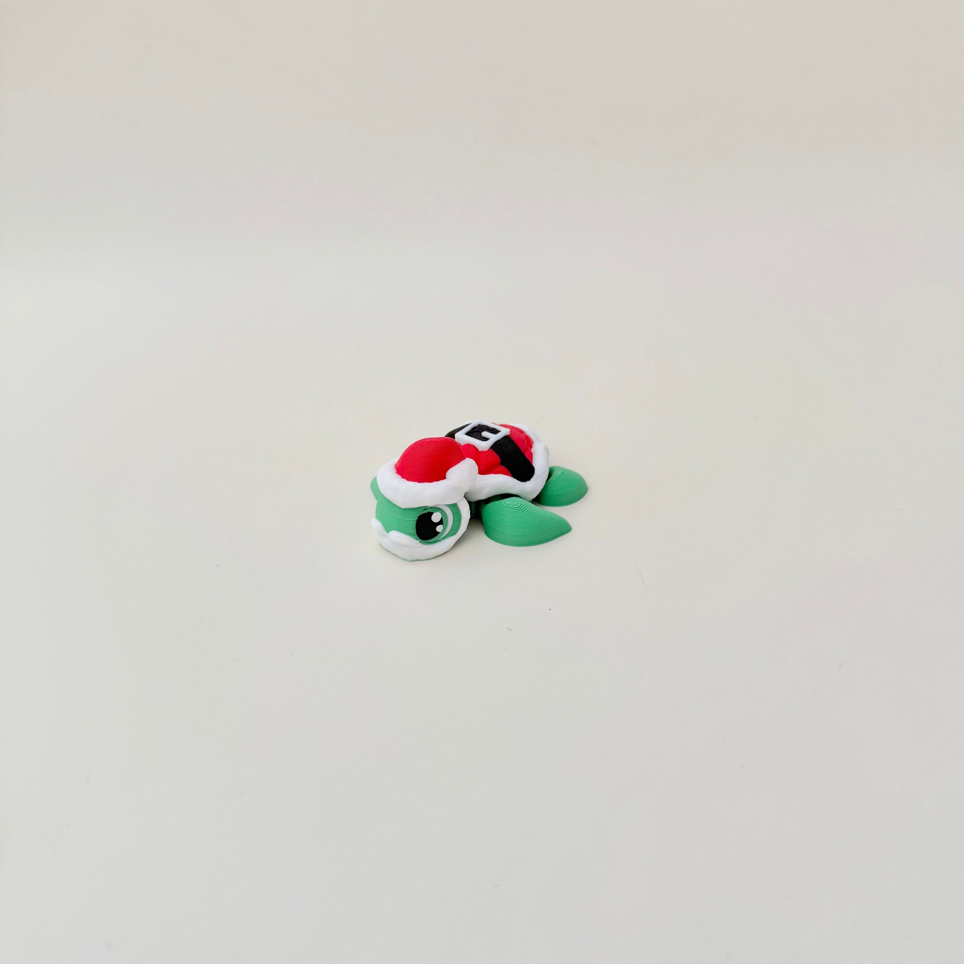 Mini turtle figure in holiday colours for desks, stockings or gift add-ons.
