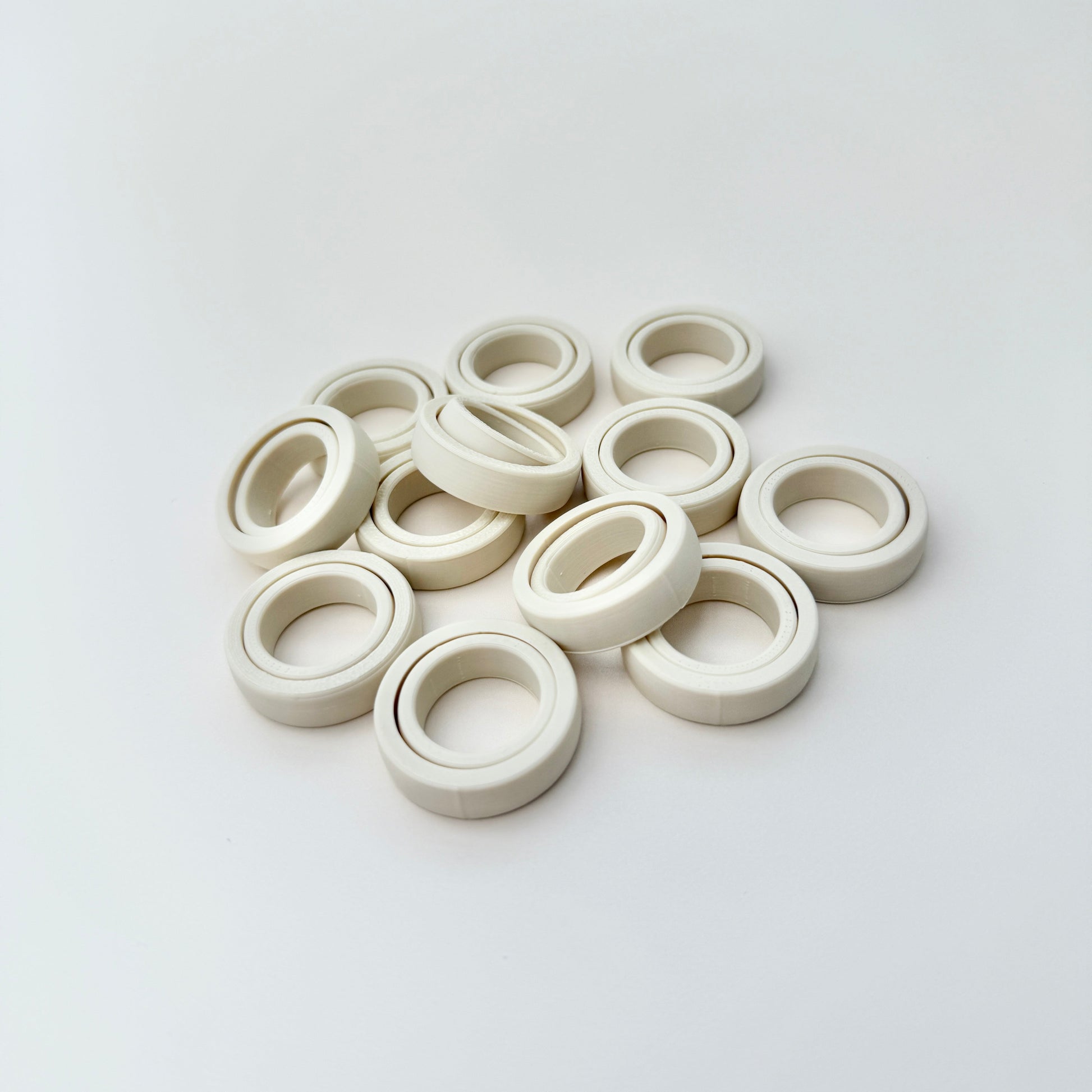 FidgiRing displayed in various sizes, ideal for adults, teens, and children, designed to fit below the knuckle for comfortable spinning.
