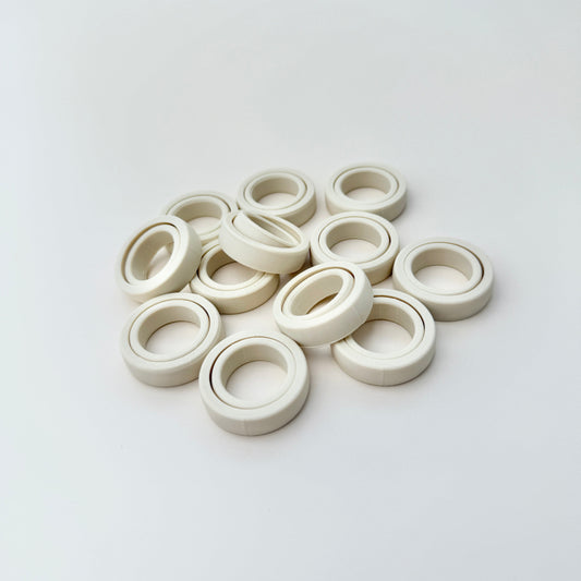 FidgiRing displayed in various sizes, ideal for adults, teens, and children, designed to fit below the knuckle for comfortable spinning.
