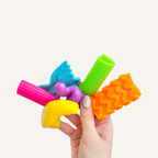 Soft textured fidget shapes with a finger hole for discreet tracing and calming sensory regulation at desks or on the go.
