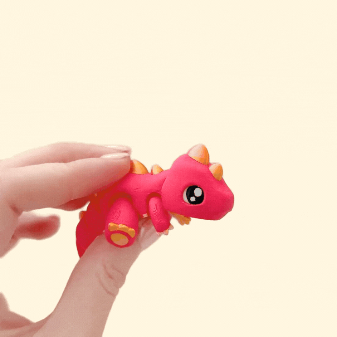 Strawberry red dinosaur fidget toy with golden spikes, claws, and paw pads. Fully articulated for play and sensory use.
