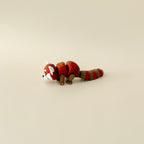 Red panda fidget toy displayed on its side, featuring its flexible tail and realistic, textured design.