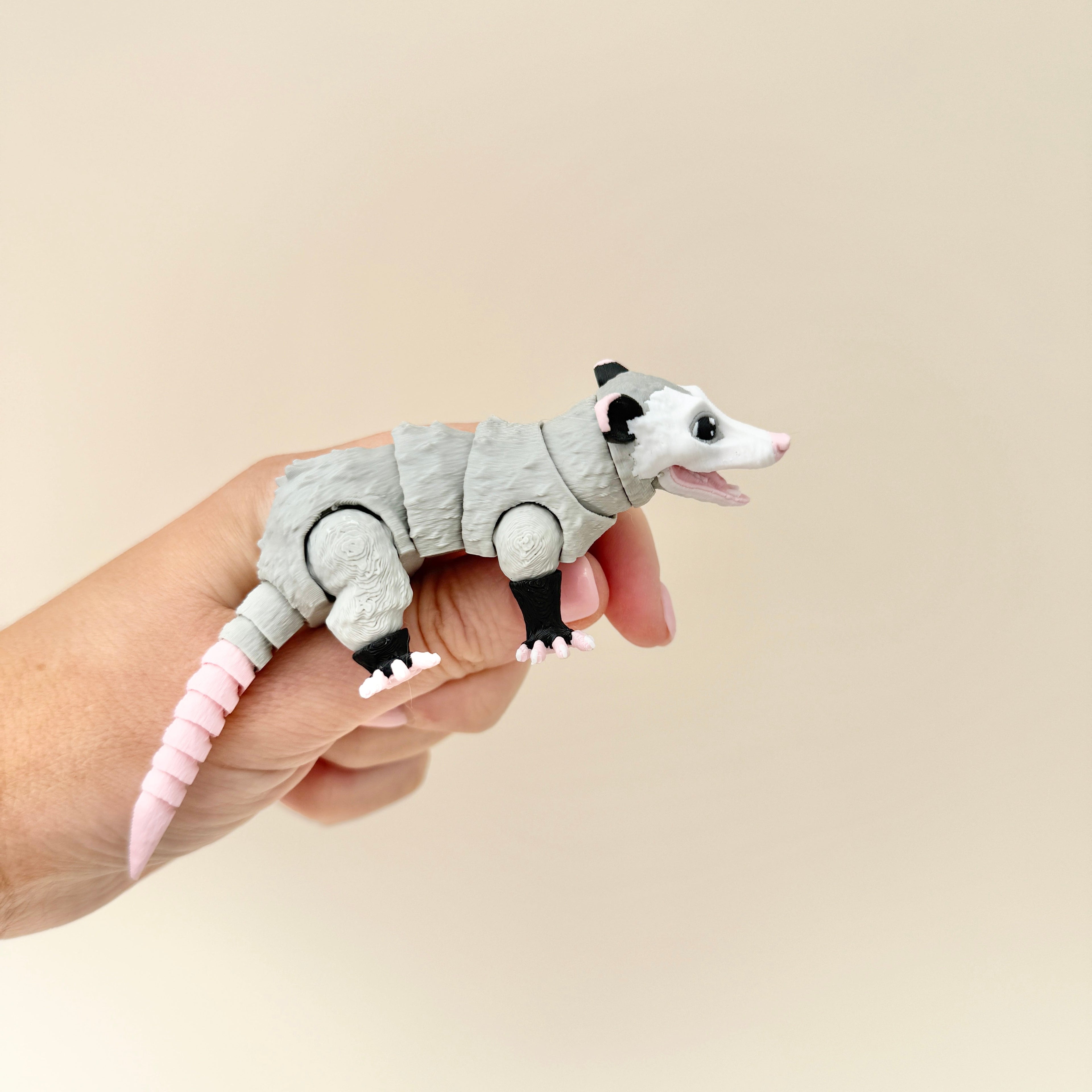A fidget possum toy with a fully flexible tail that can curl or straighten, perfect for sensory play and display.