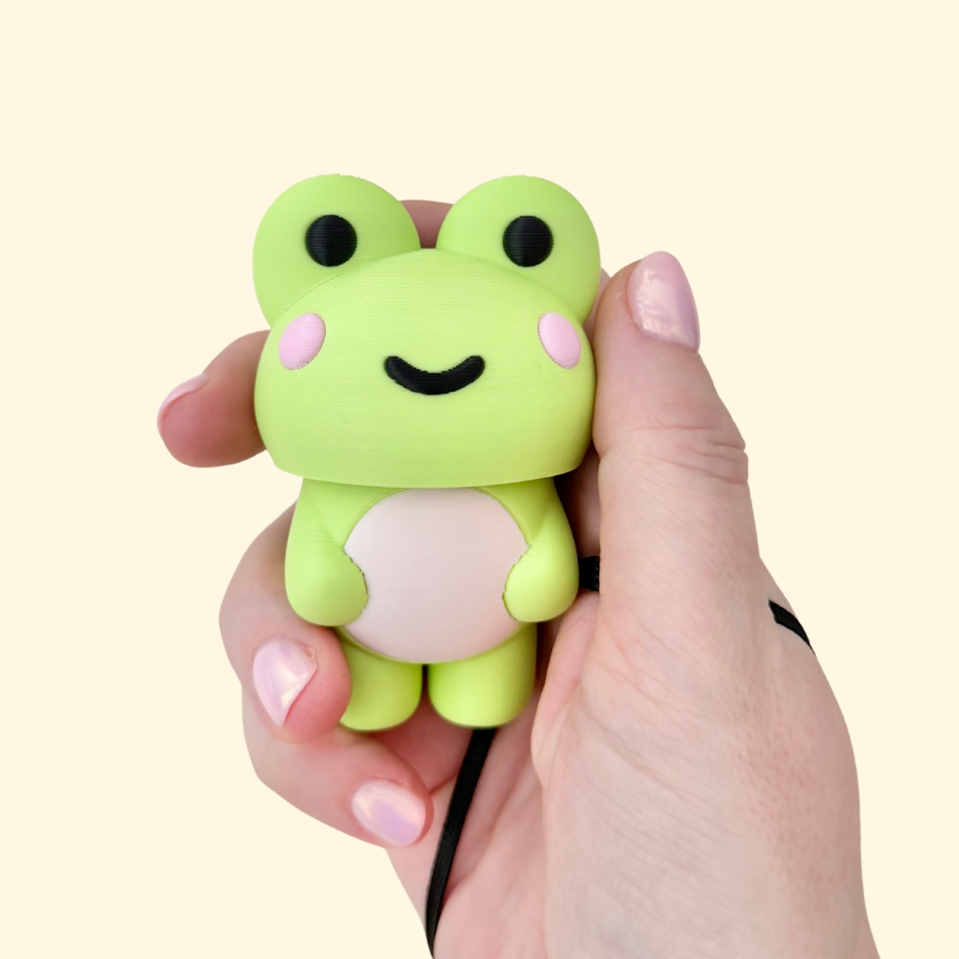 A large frog-shaped clicker fidget with smooth curves and a wrist strap for carrying
