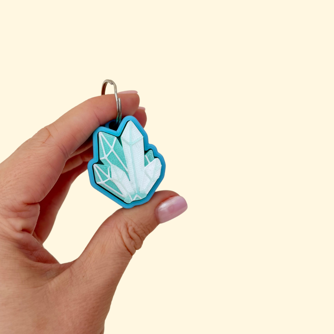 Blue-white crystal clicker keyring; textured facets for tracing; press to click; optional quiet version for low-noise fidgeting.
