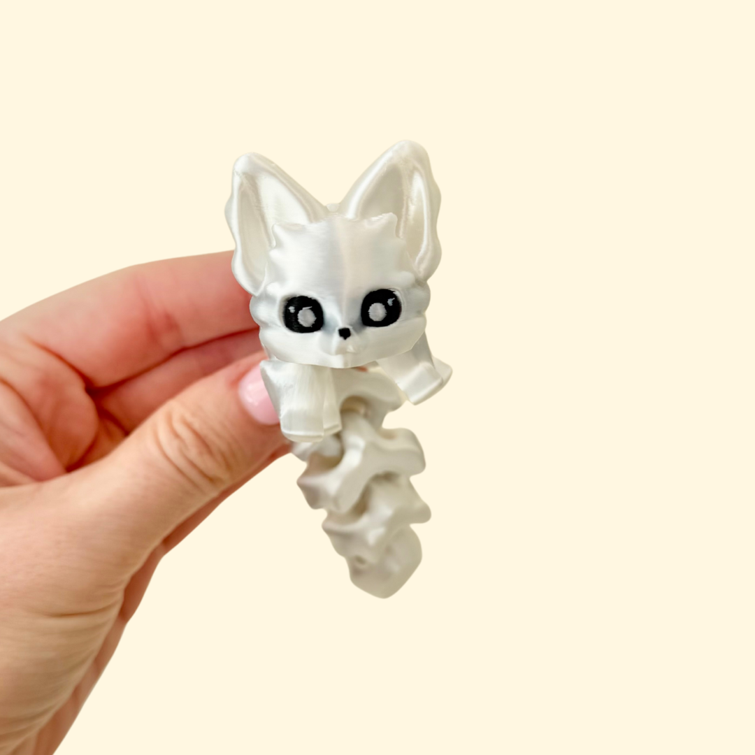 Articulated arctic fox fidget, 13 cm, shiny white PLA with smooth segments for calm stimming and desk play.
