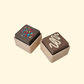 Mini fudge clicker fidget with sprinkles or drizzle top, pocket-sized, satisfying press, optional quiet click upgrade.
