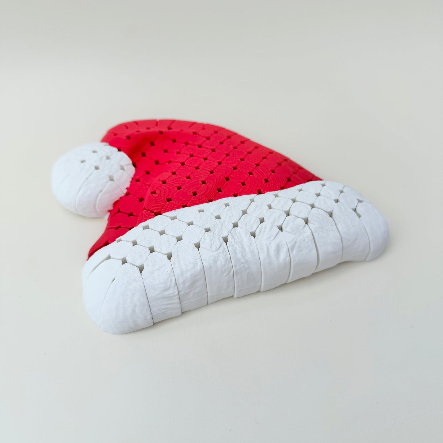 Red and white flexible Santa hat laid flat, 16 cm mesh build for tracing and calming sensory input.
