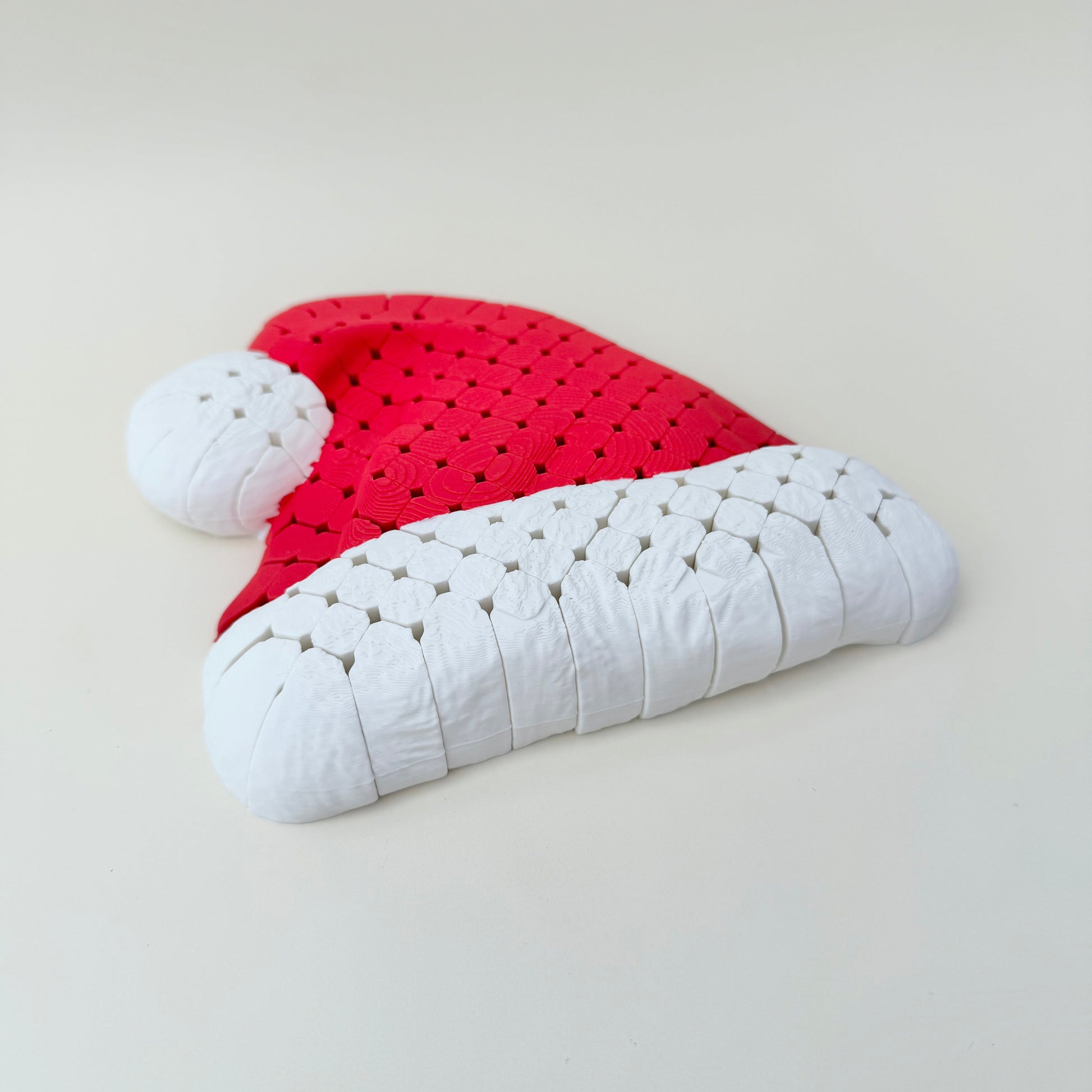 Red and white flexible Santa hat laid flat, 16 cm mesh build for tracing and calming sensory input.
