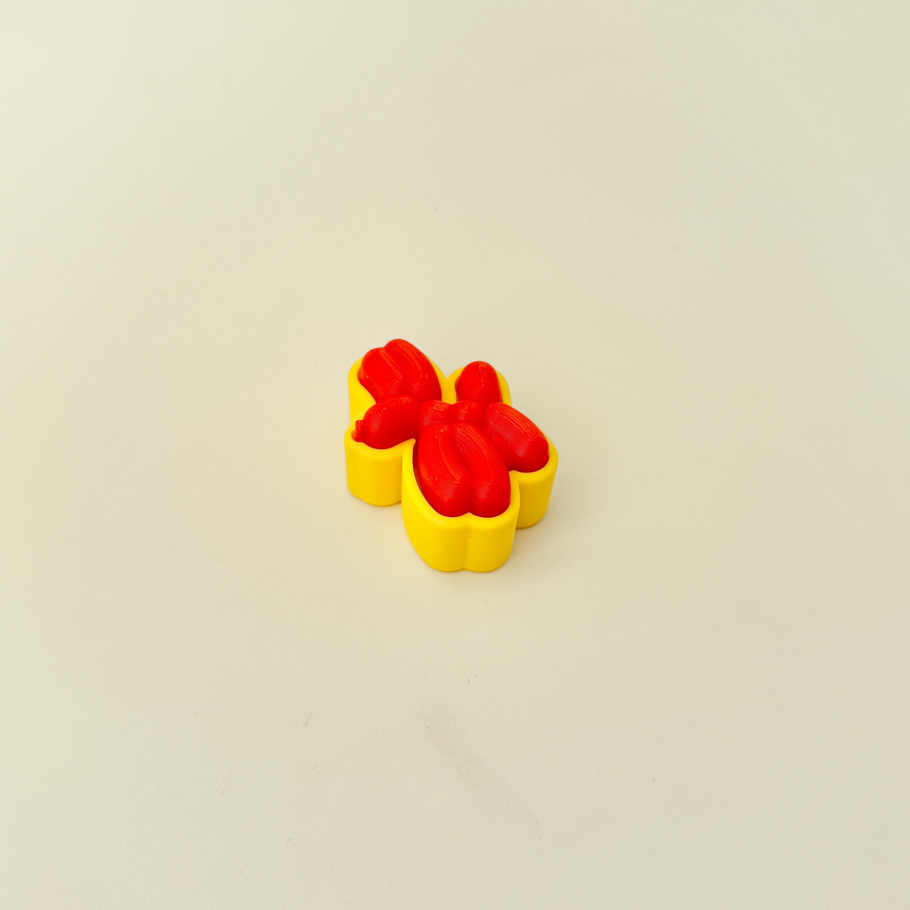 Compact sensory toy with a balloon animal design and pressable clicker centre.