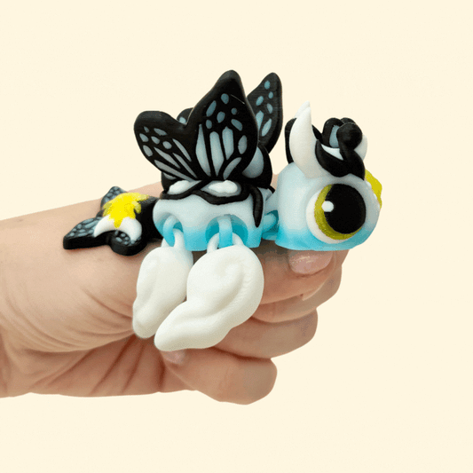 Gradient blue and white turtle with butterfly-style wings and golden sun detail