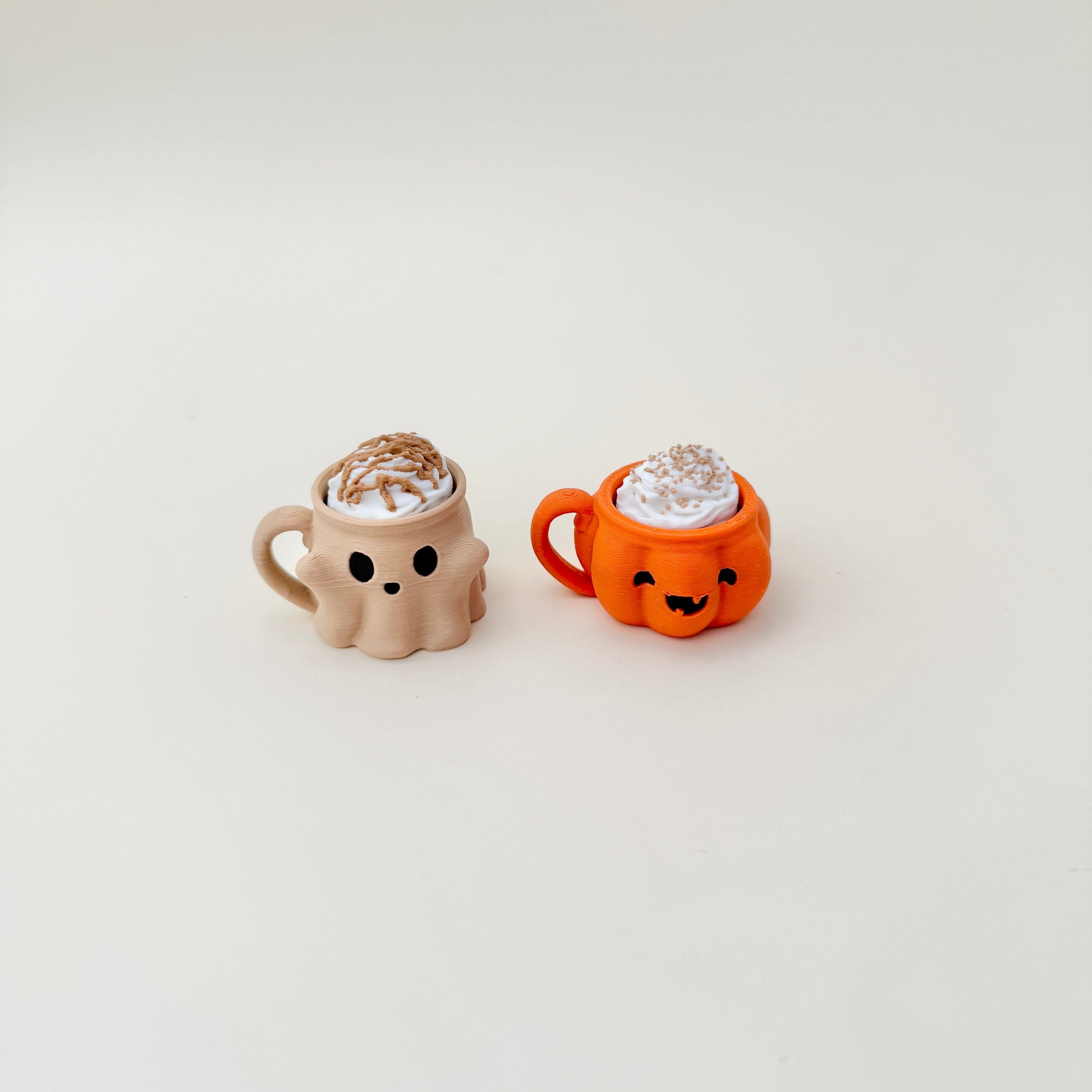 Nude ghost-face mug with textured cream swirl designed for handheld clicking.
