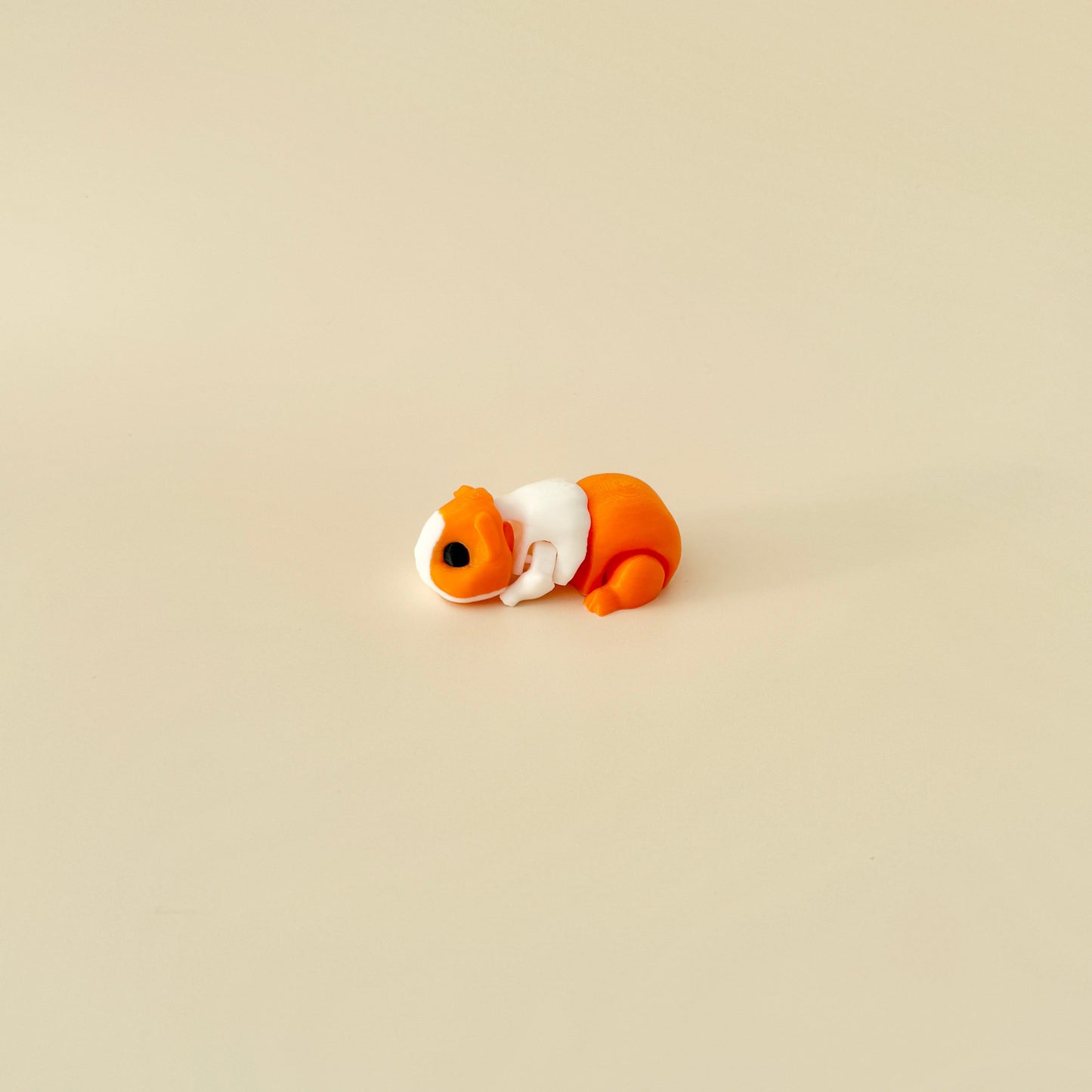 Ginger and white guinea pig fidget toy with a fully flexible body, ideal for stress relief.
