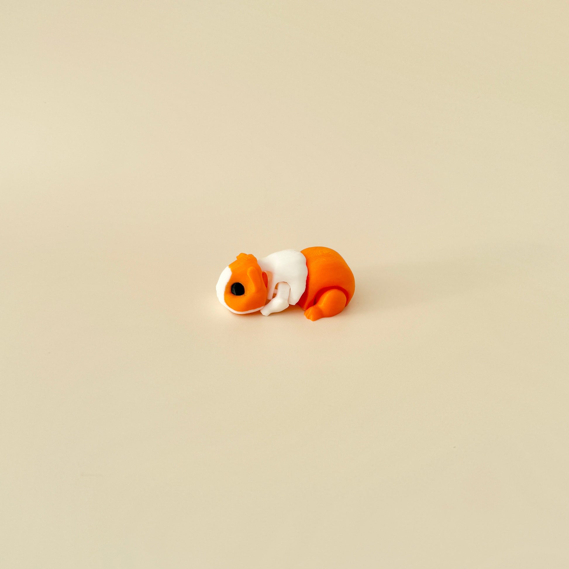 Ginger and white guinea pig fidget toy with a fully flexible body, ideal for stress relief.