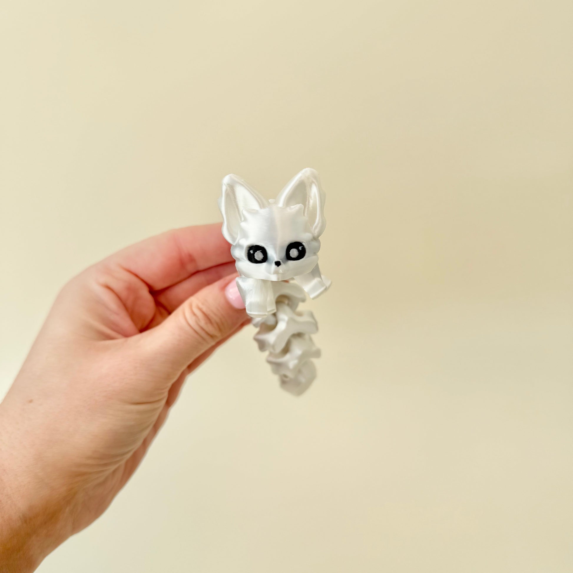 Compact articulated fox toy in pearly white; gentle ridges for tracing and sensory regulation.
