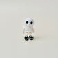 Black cat slippers on a white skeleton with luminous eyes for a playful spooky touch.
