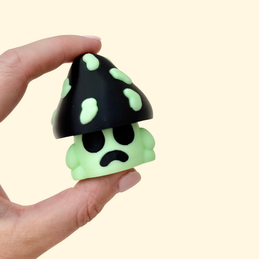 mushroom-shaped sensory clicker with a pressable cap and glow-in-the-dark details
