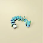 Flexible articulated snake fidget with blue-purple-green gradient and heart tail; smooth wiggle for calming sensory input.
