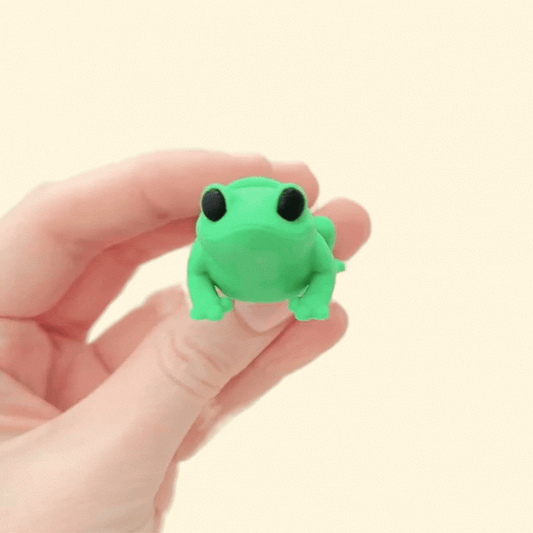 Fully articulated green frog fidget toy with black eyes, designed for sensory play.