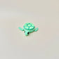 Turtle clicker toy in shades of green and blue, with 7 clickers and a flexible body for tactile play.