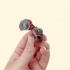 Red and black glitter fidget turtle with creepy-cute features.