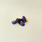 Cute seasonal crow charm with glitter sheen and an iridescent purple hat.