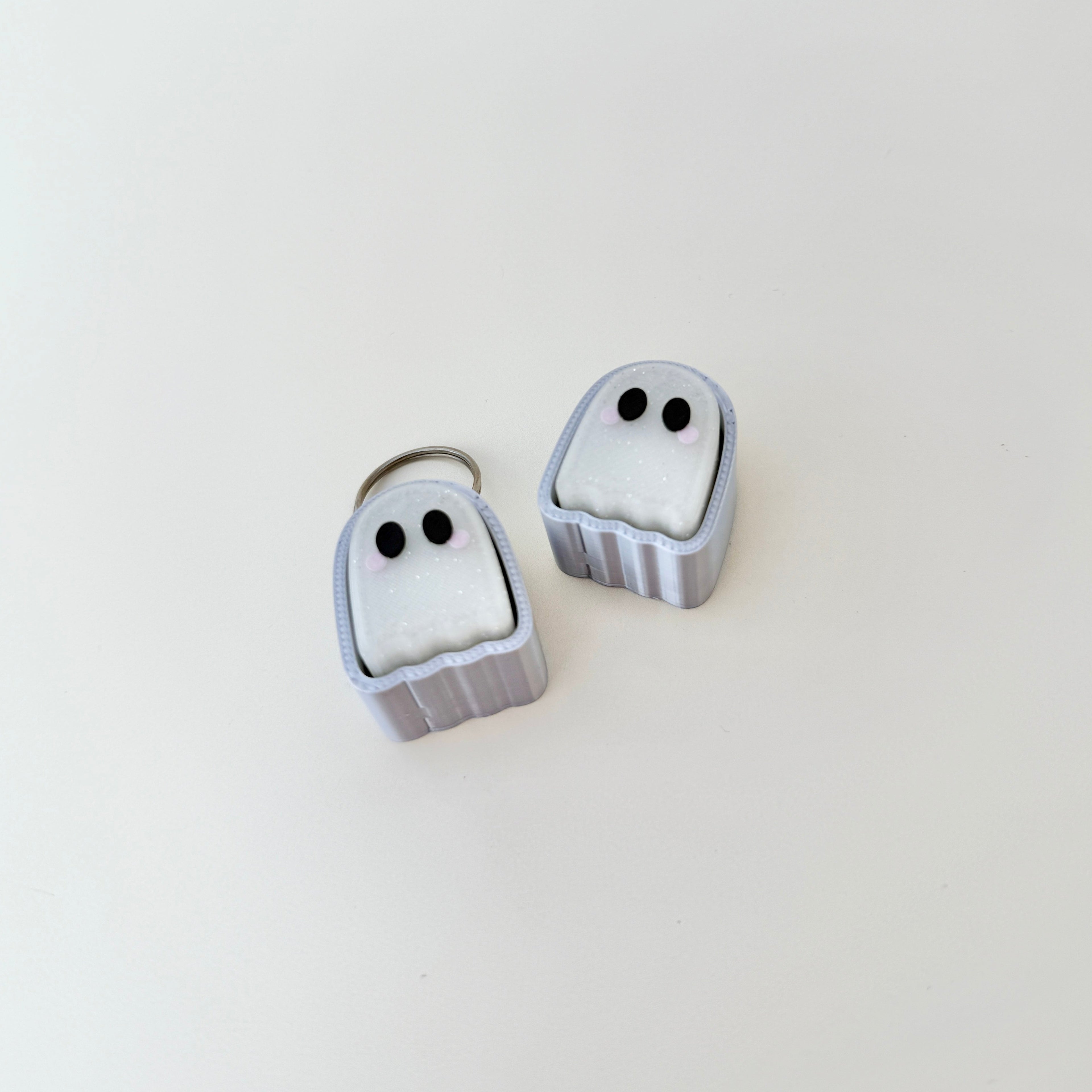 Compact ghost-shaped clicker with silver keyring loop
