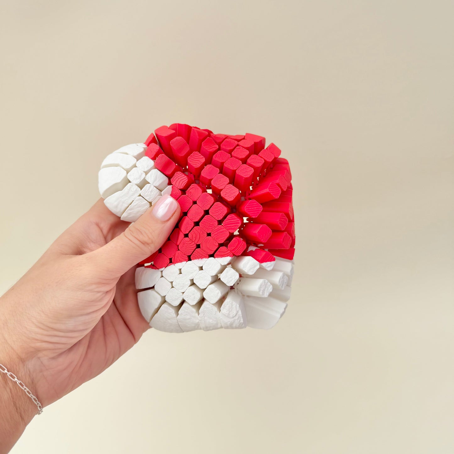 Large flexible Christmas hat fidget shown in hand, soft bend and quiet articulation for tactile stimming.
