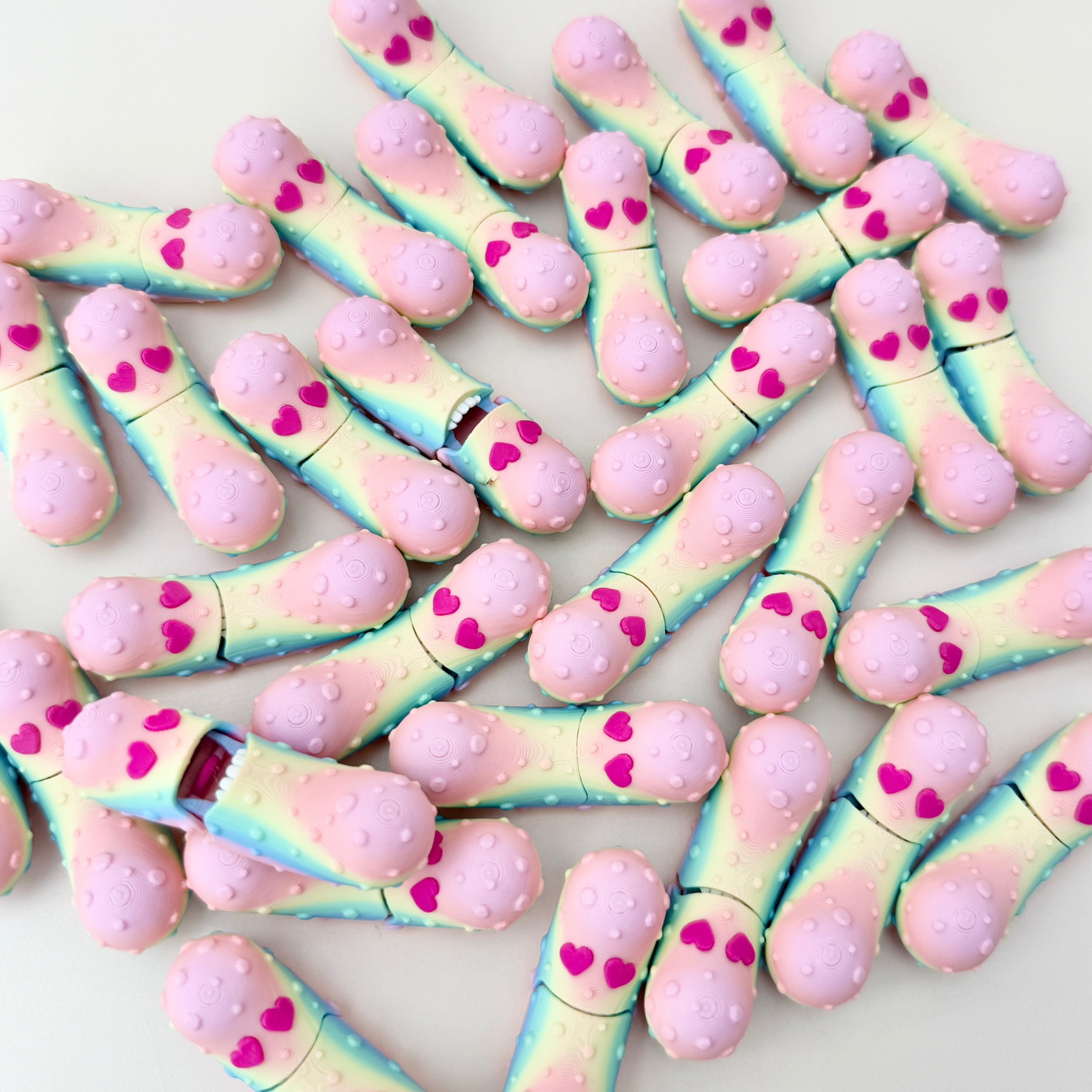 A compact 5cm pickle fidget toy with vibrant rainbow filament and red heart eyes.