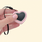 A heart-shaped clicker fidget toy with a pink ridged outer section and a black centre.