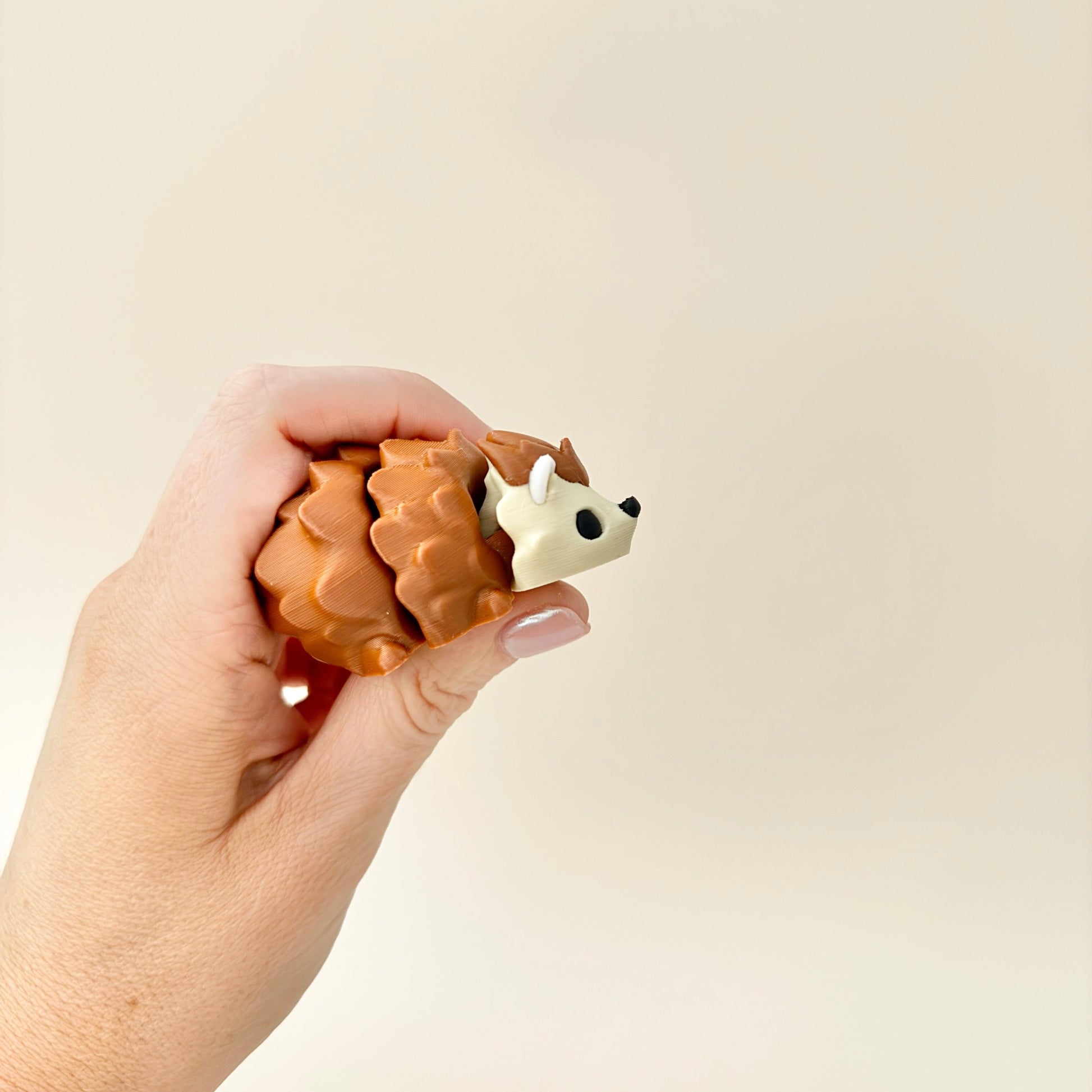 Hedgehog fidget toy in iridescent rainbow colours with a black nose and eyes, fully articulated for sensory play.