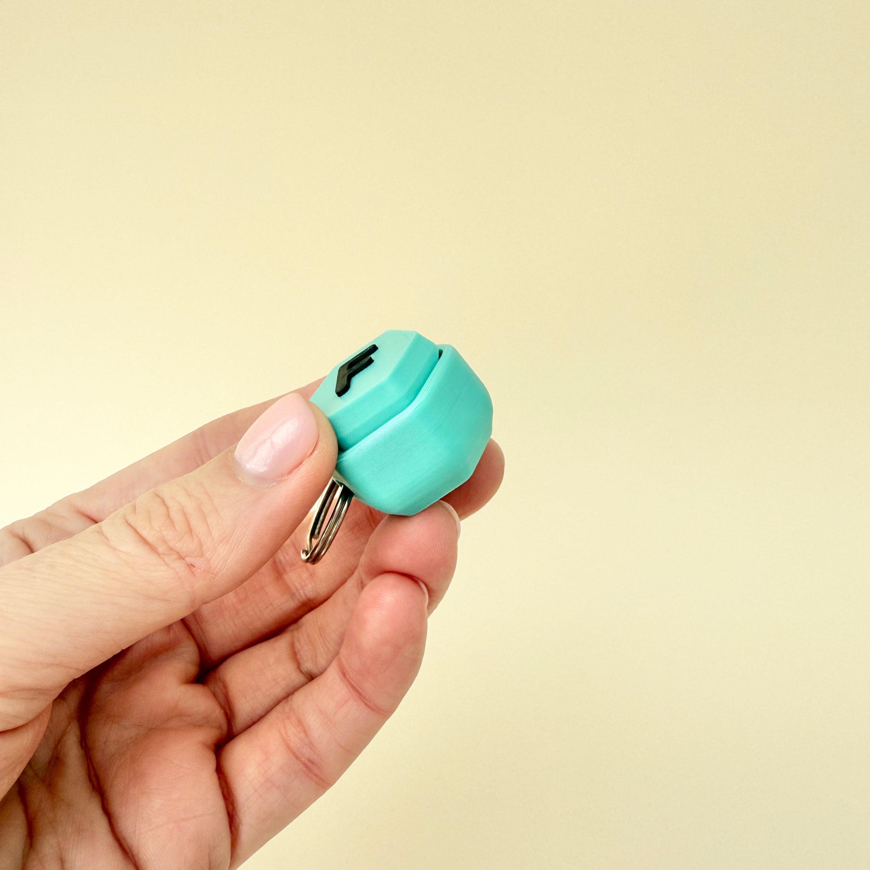 A stylish fidget keyring with a black raised letter, providing satisfying sensory feedback.