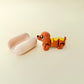 Compact articulated sausage dog with ridged bun; calming, click-free stim toy.
