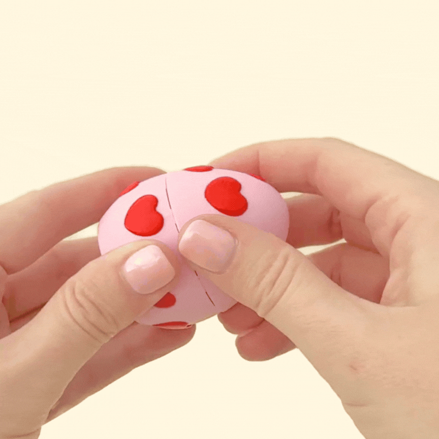 A cute fidget toy featuring a teddy bear inside a heart-patterned egg, designed for sensory play and gifting.