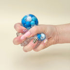 Soft sensory fidget that pops straight back after squeezing, offering visual swirl feedback and calming hand stimulation.
