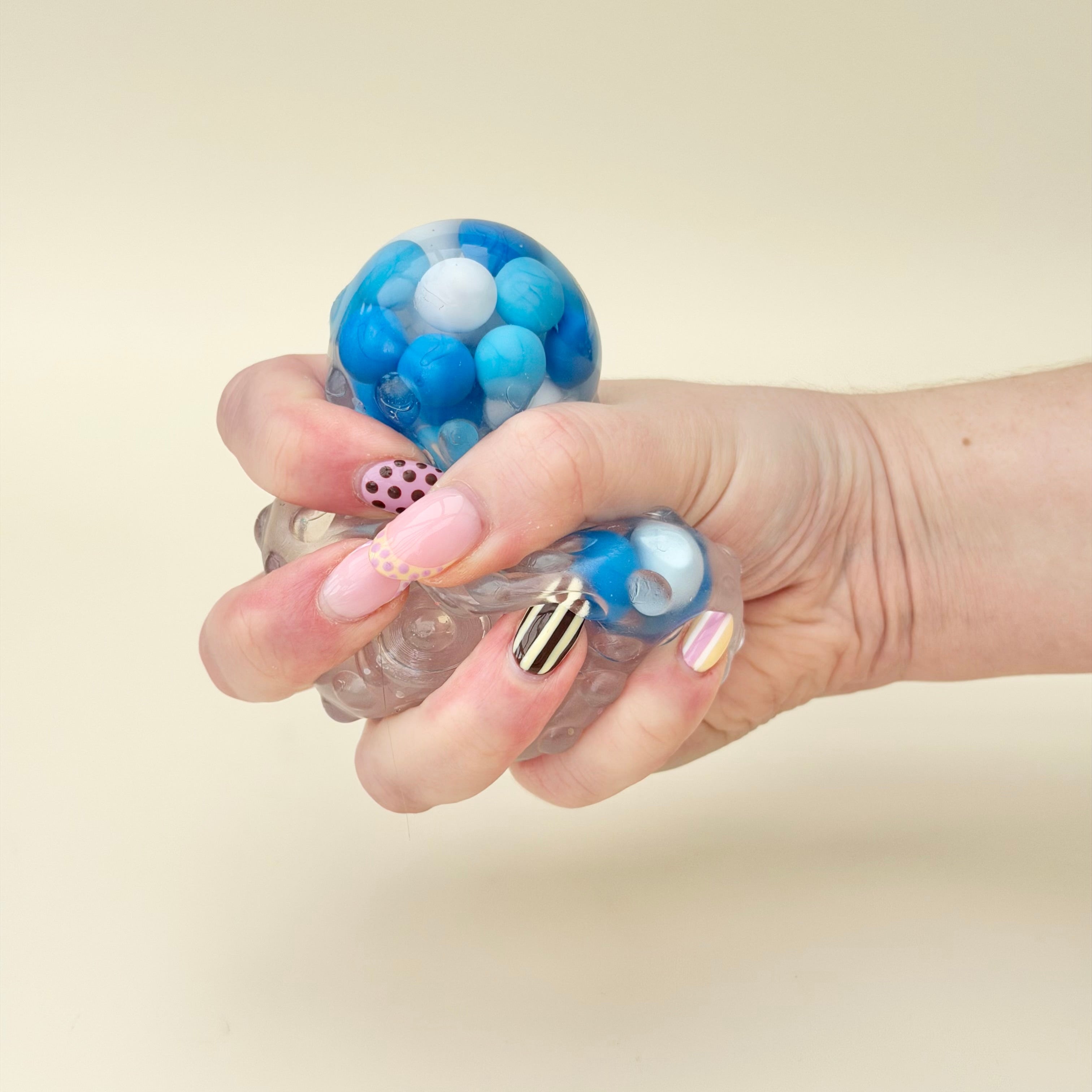 Soft sensory fidget that pops straight back after squeezing, offering visual swirl feedback and calming hand stimulation.
