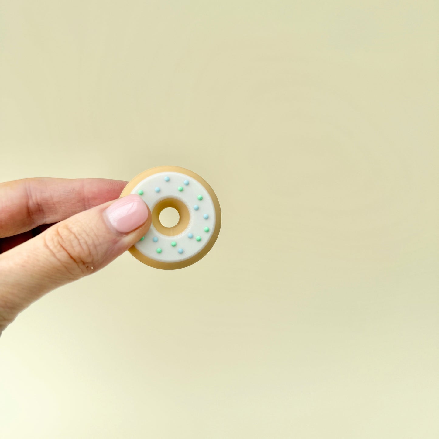 A two-piece magnetic fidget doughnut that flips and spins in hand, providing a satisfying sensory experience.