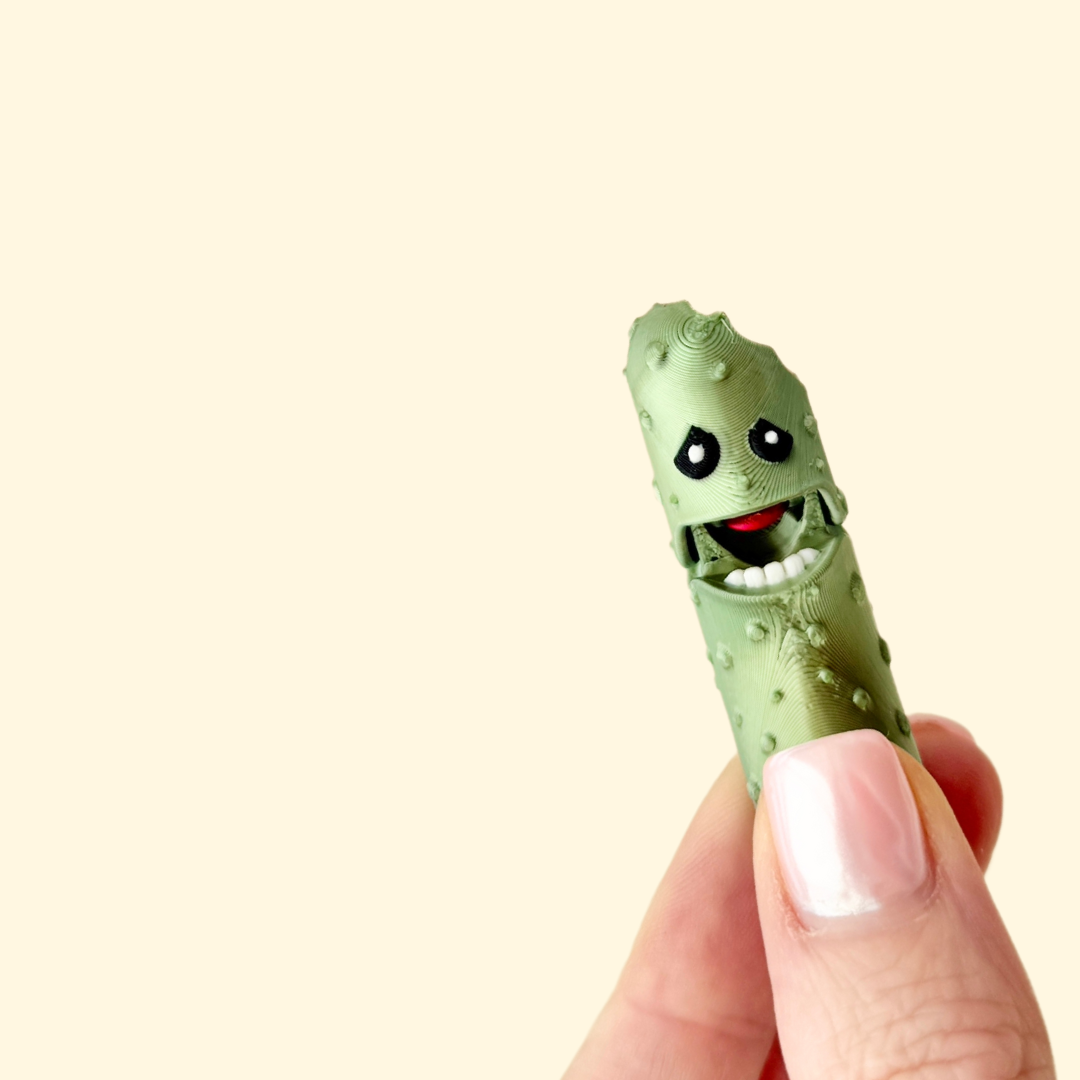 Metallic green pickle fidget toy with a bitten detail, offering fun and satisfying movement.