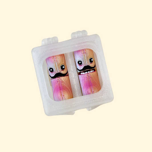 pair of quiet jumping-bean style fidgets with flip mouths in a compact clear case
