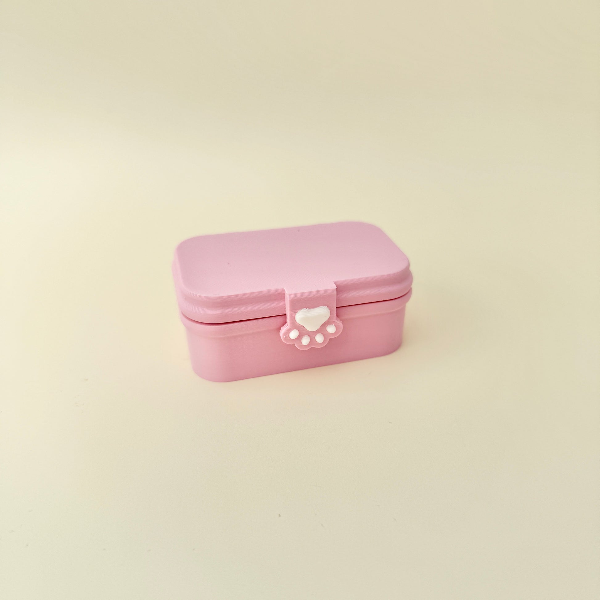 Bento clicker in a paw-clasp box with three pressable buttons; portable and giftable.
