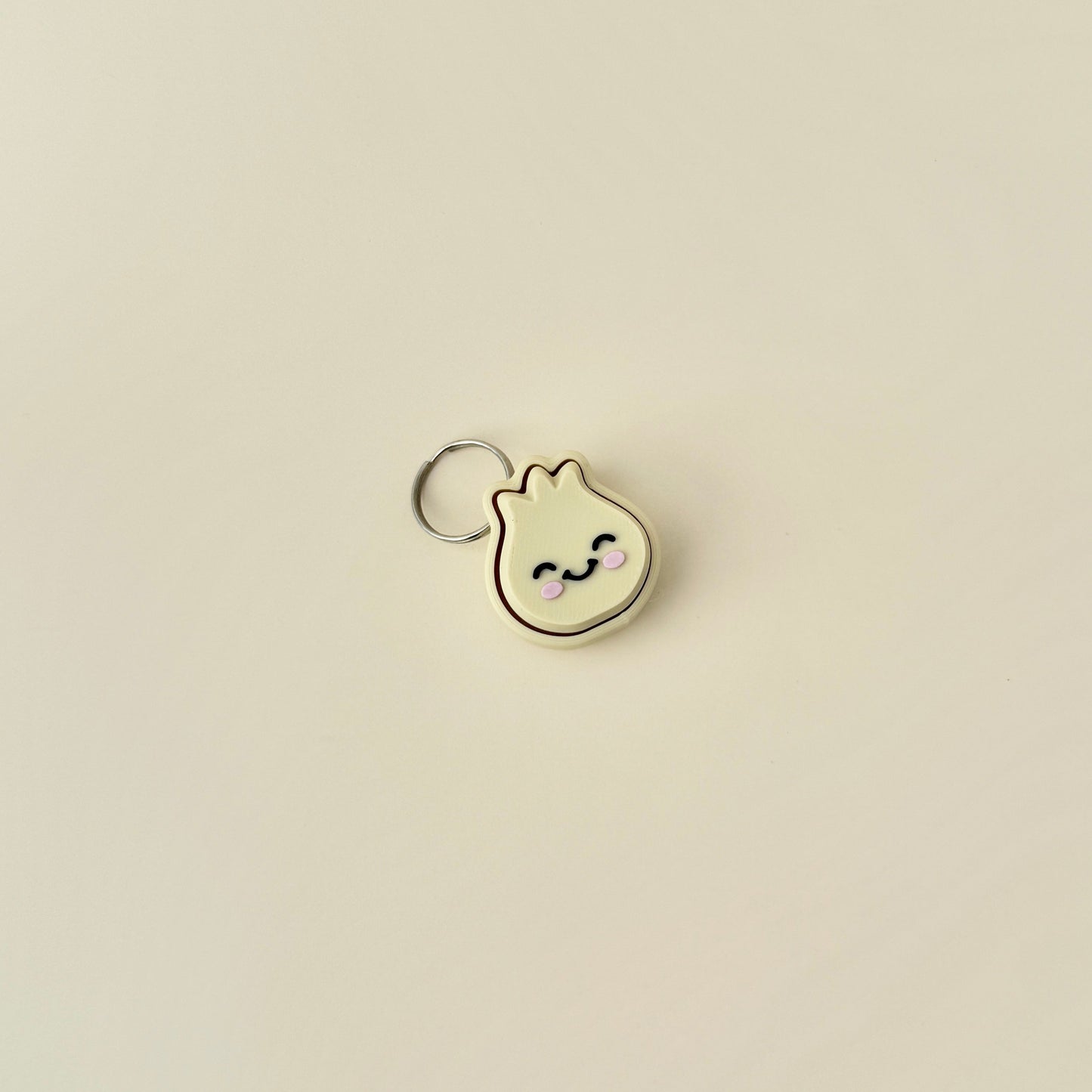 A cute, small dumpling clicker with a keychain, featuring a soft press mechanism that makes an audible clicking noise.